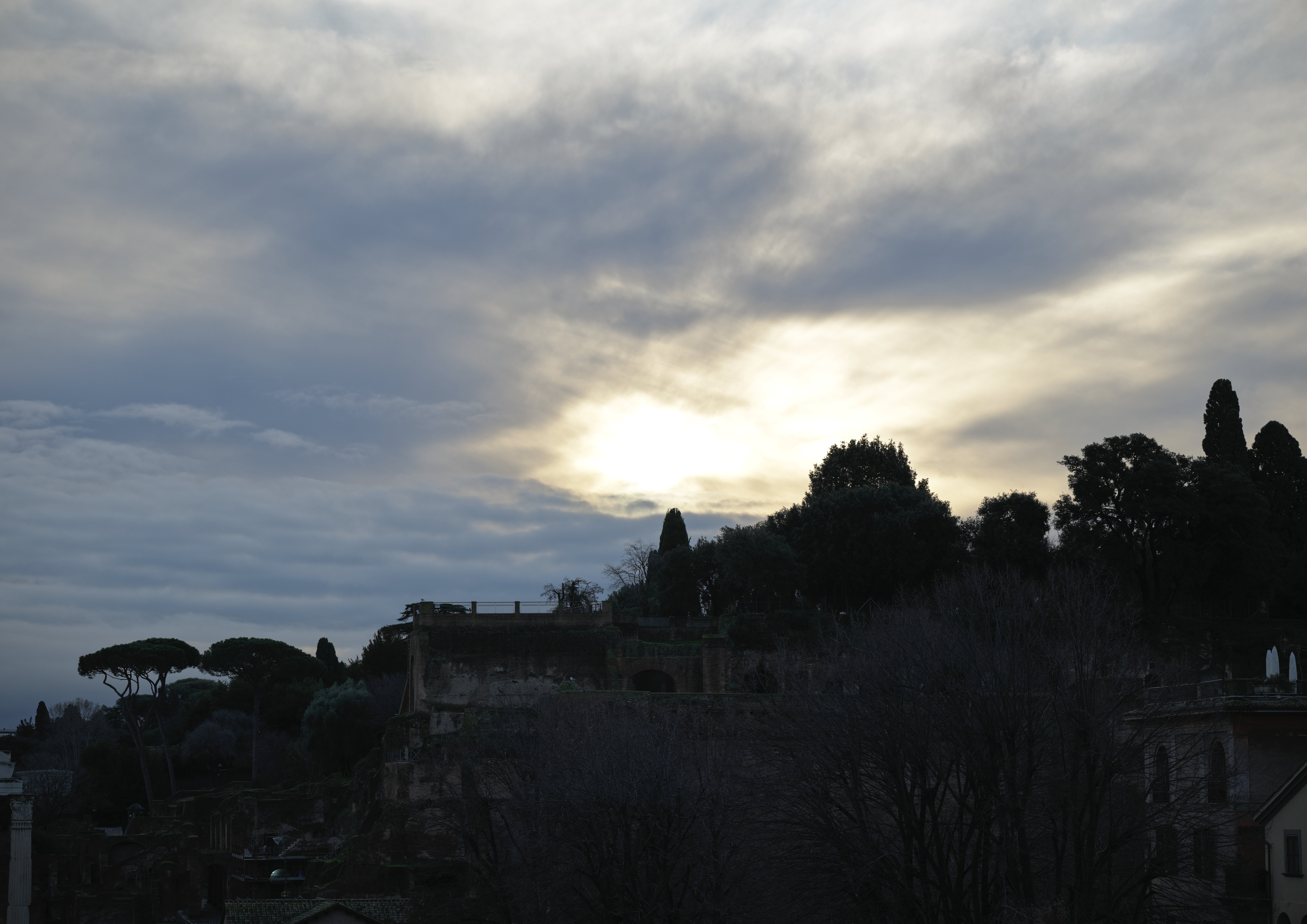 Rome sunset scene with HDR on, showing richer cloud detail, controlled highlights, and improved shadow visibility in trees and buildings.