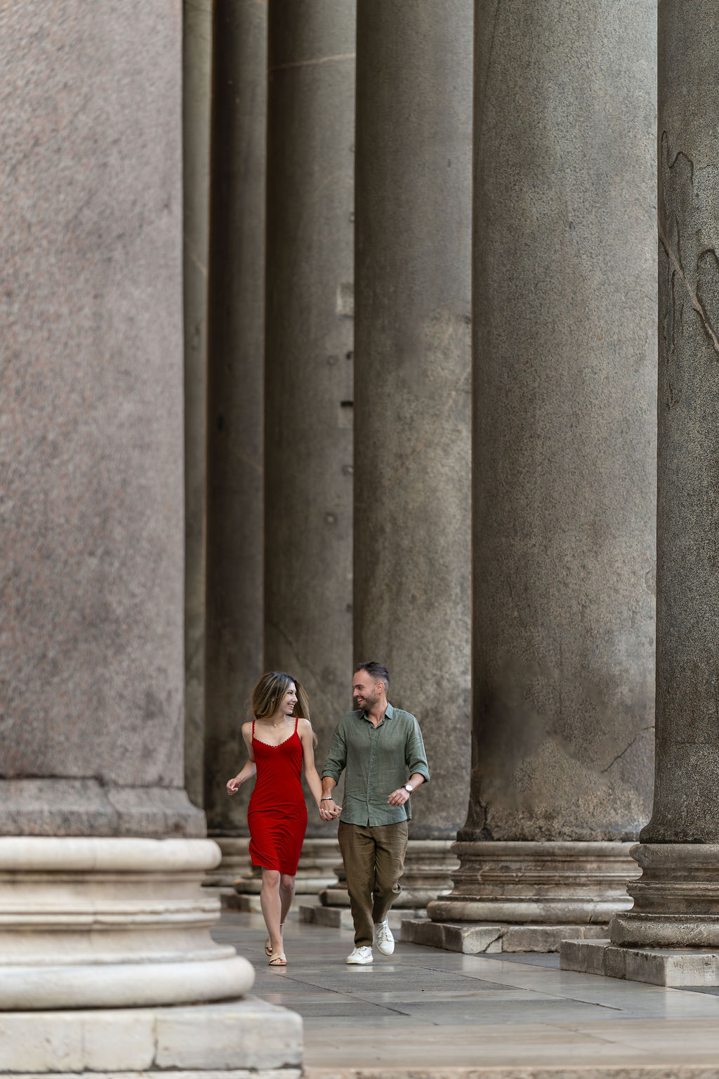Couple walking under the Pantheon colonnade in Rome after a surprise proposal, Piazza della Rotonda, Eidos Photography, Rome photographer.