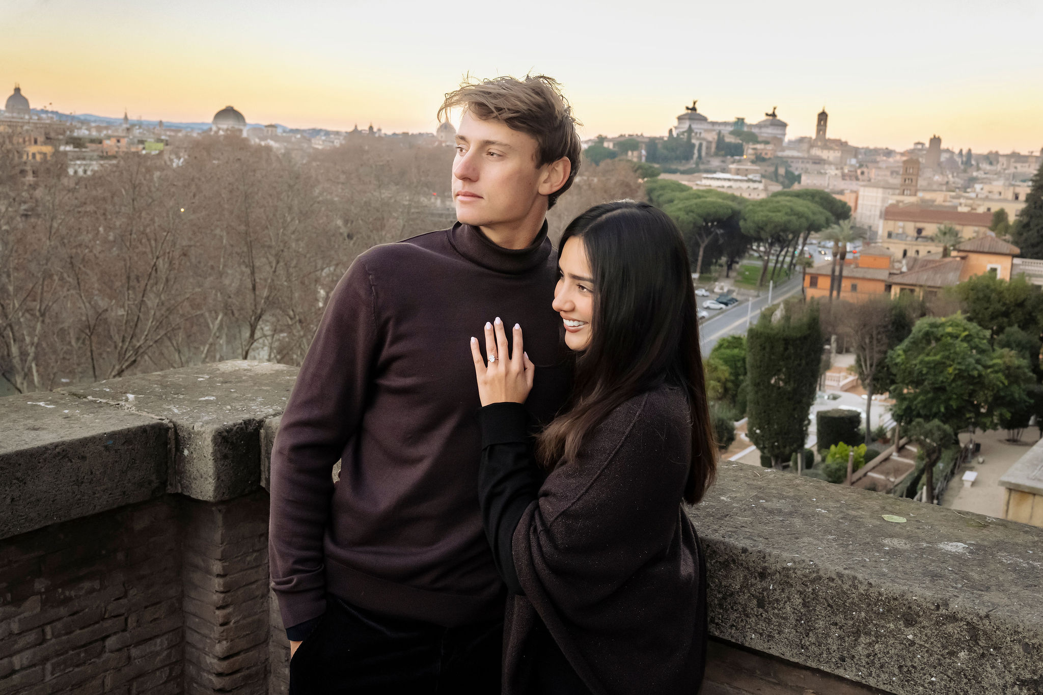 Couple embracing at Pincio Terrace in Villa Borghese with panoramic views of Rome in the background. The romantic portrait highlights the city’s skyline during a private photoshoot by Eidos Photography.