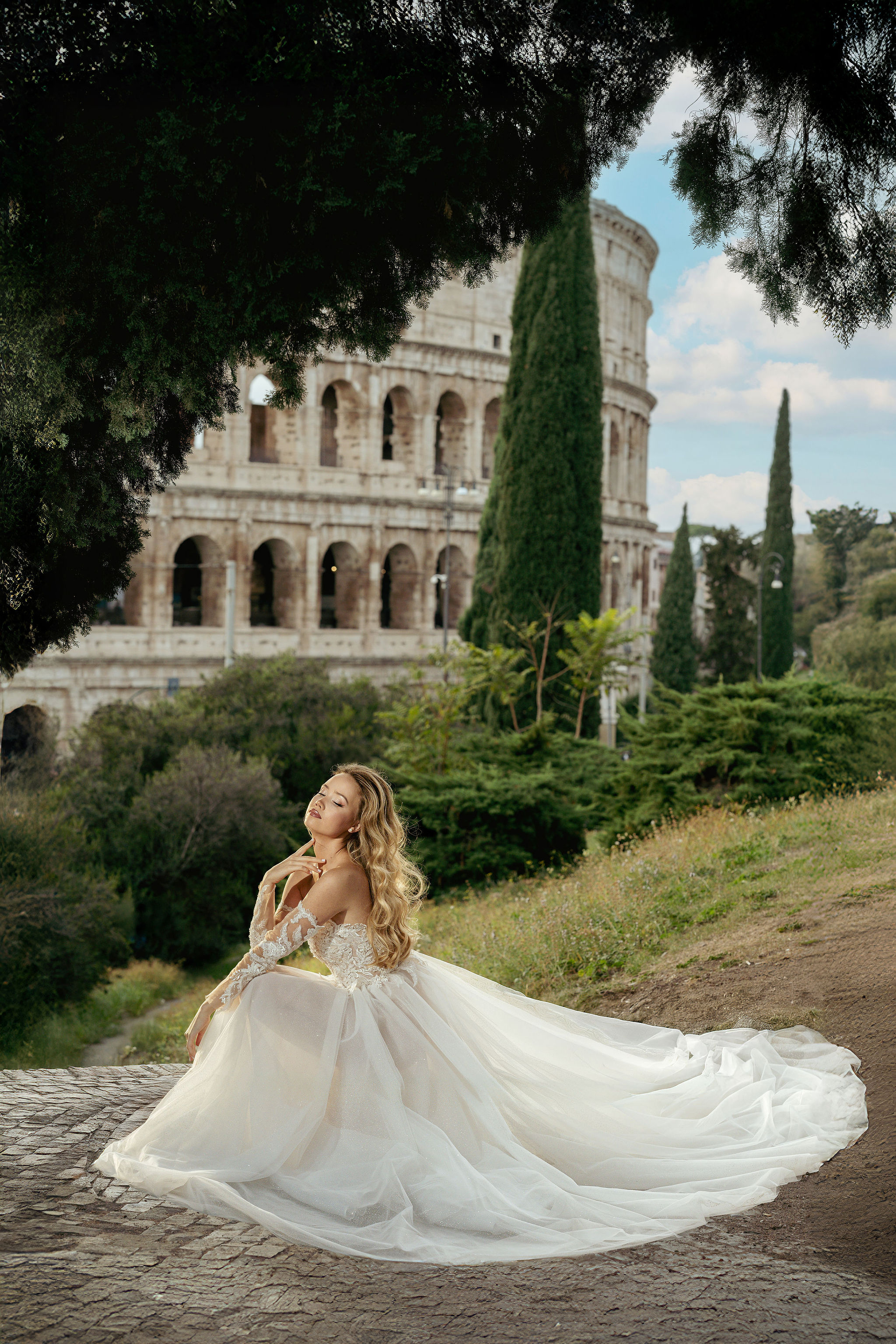 Bride in a white gown posing at Fontana dei Petali during a golden-hour Colosseum photoshoot in Rome.