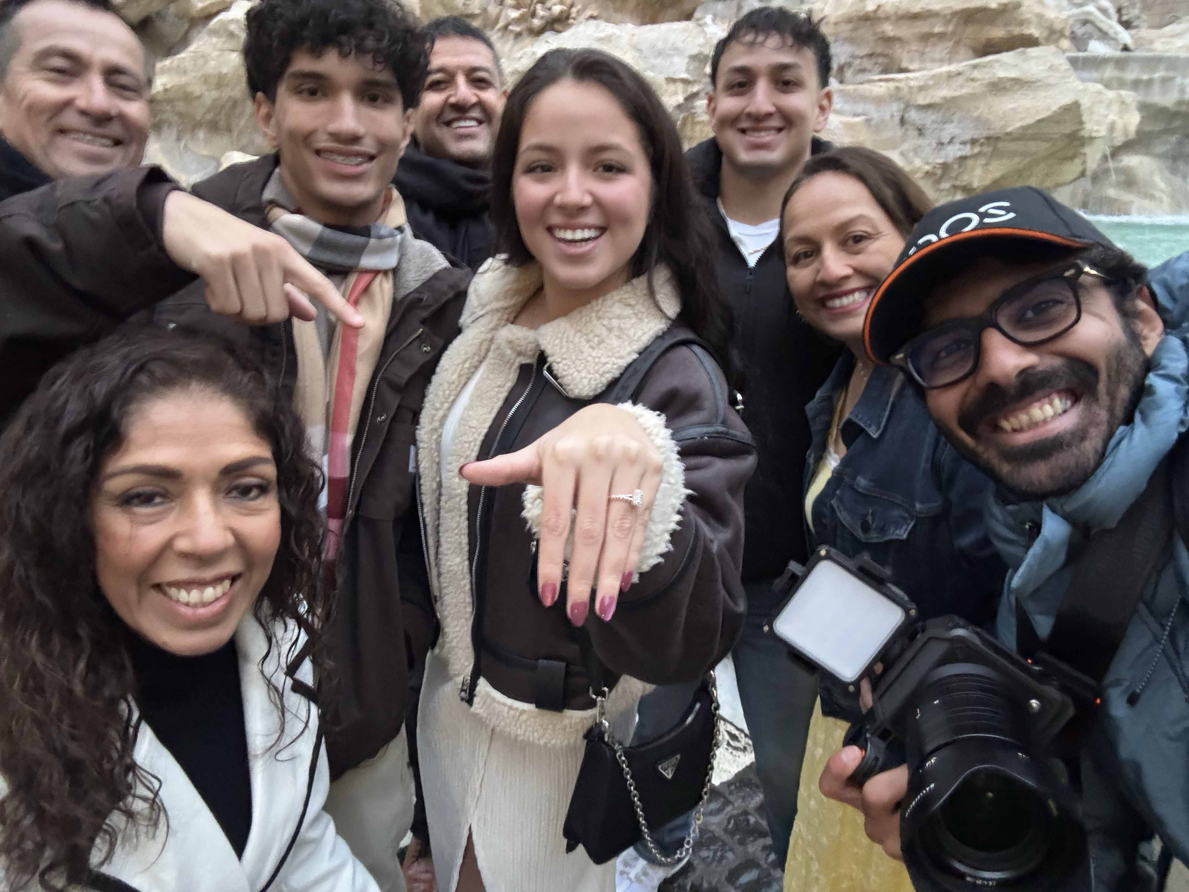 Rome photographer celebrating with a newly engaged couple and their friends after a surprise proposal photoshoot at Trevi Fountain.