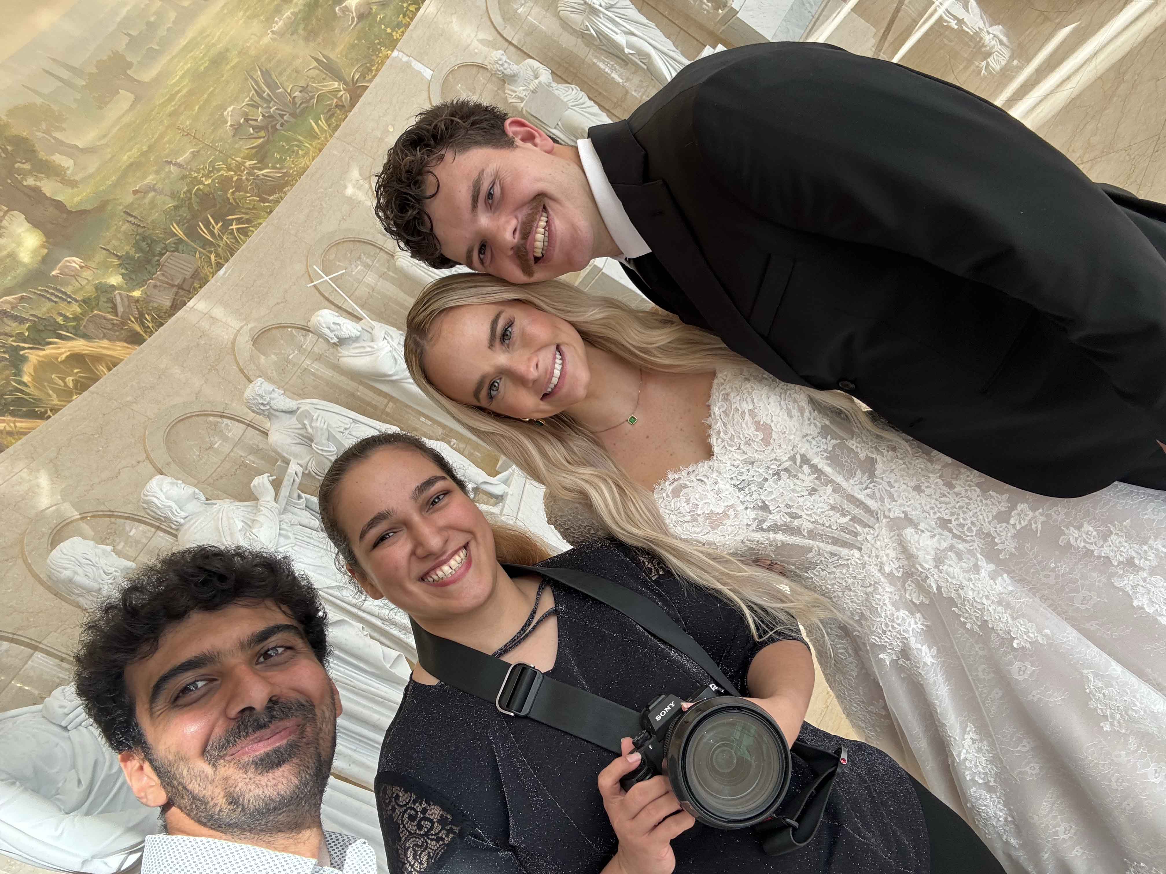 Rome photographers Jeff and Sara from Eidos Photography taking a selfie with a newlywed couple after their wedding photoshoot.
