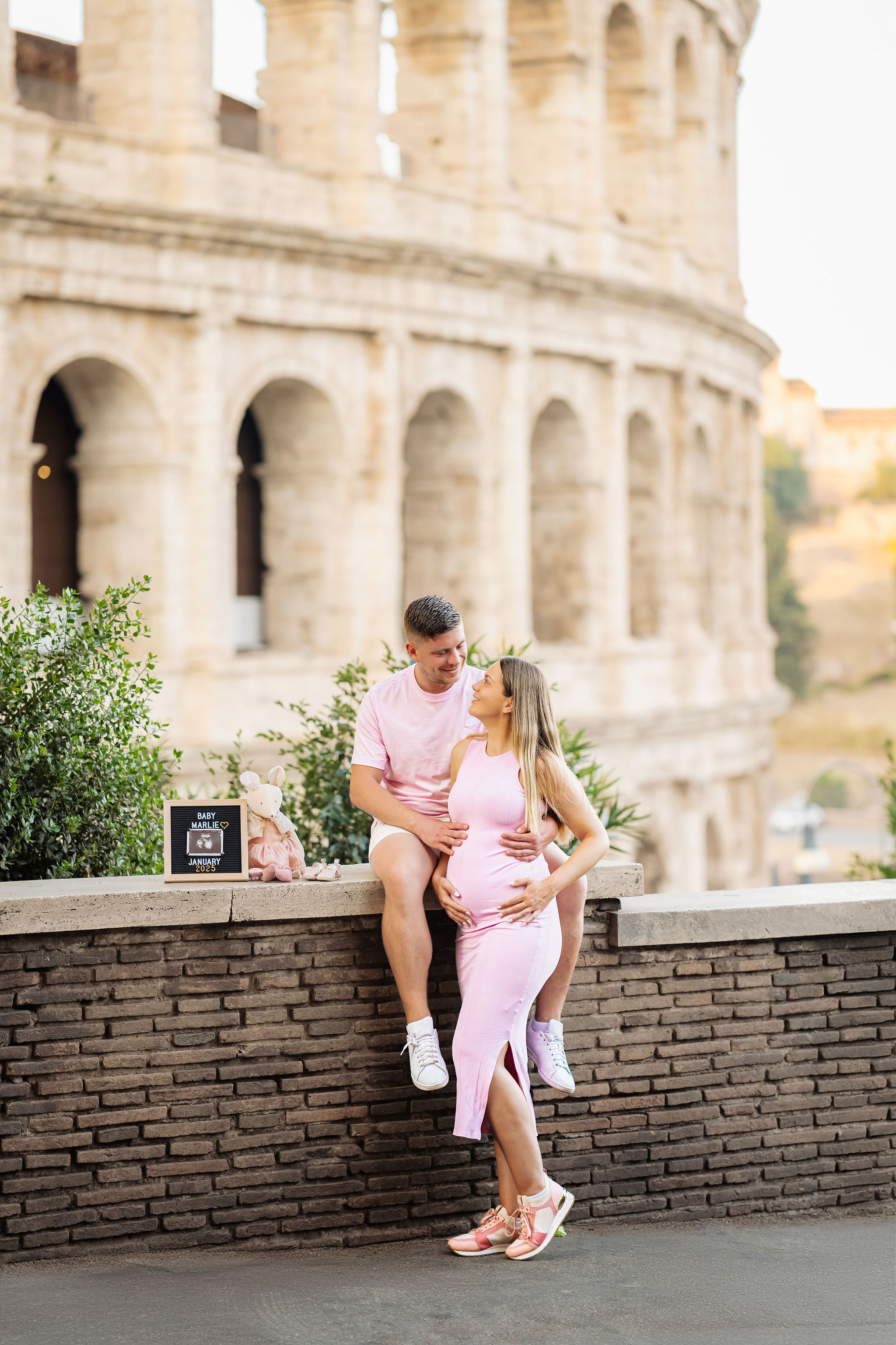     Natural babymoon portrait of an expectant couple in front of the Colosseum.