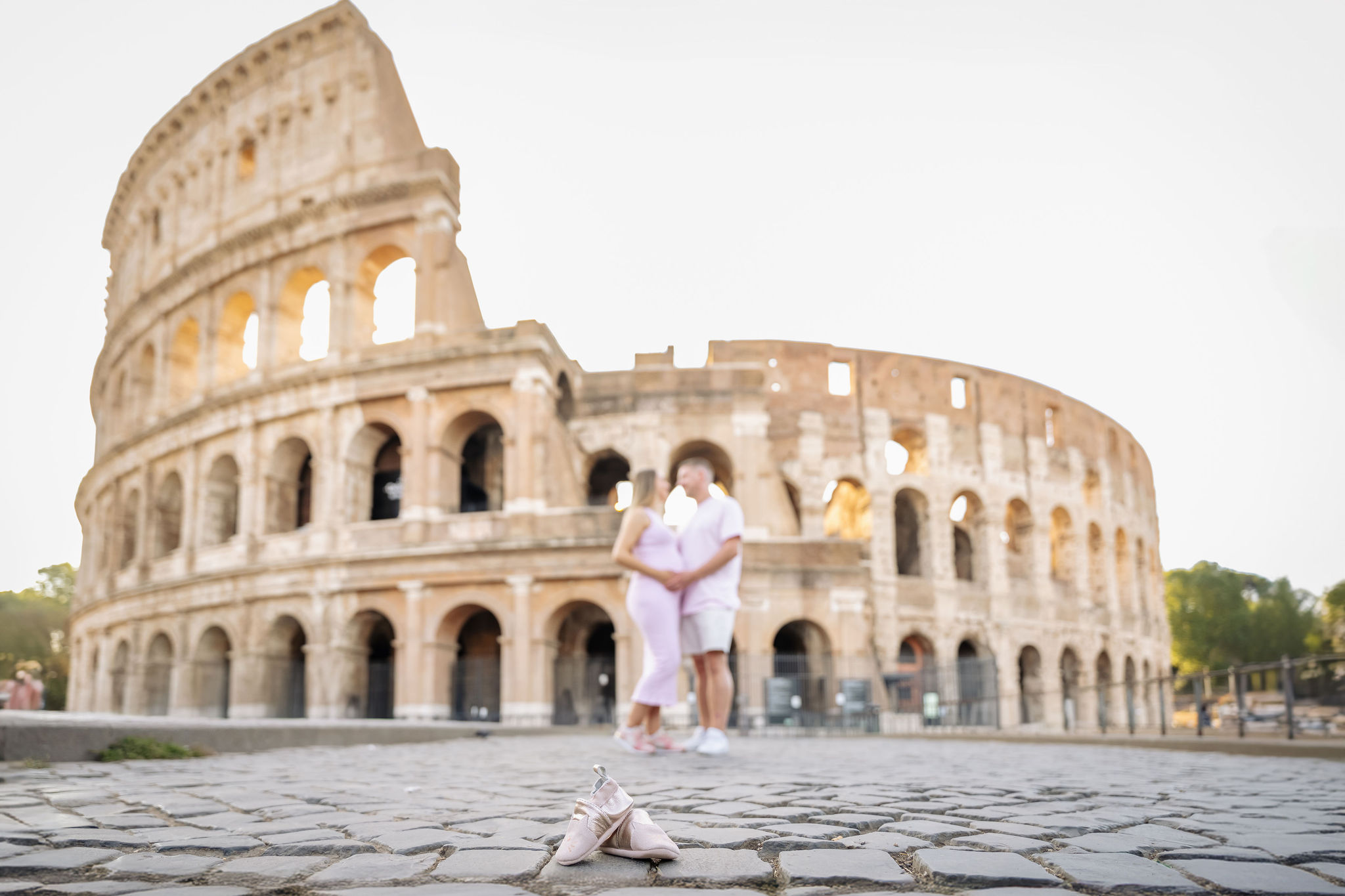     Couple celebrating their pregnancy with a maternity portrait beside the Colosseum.