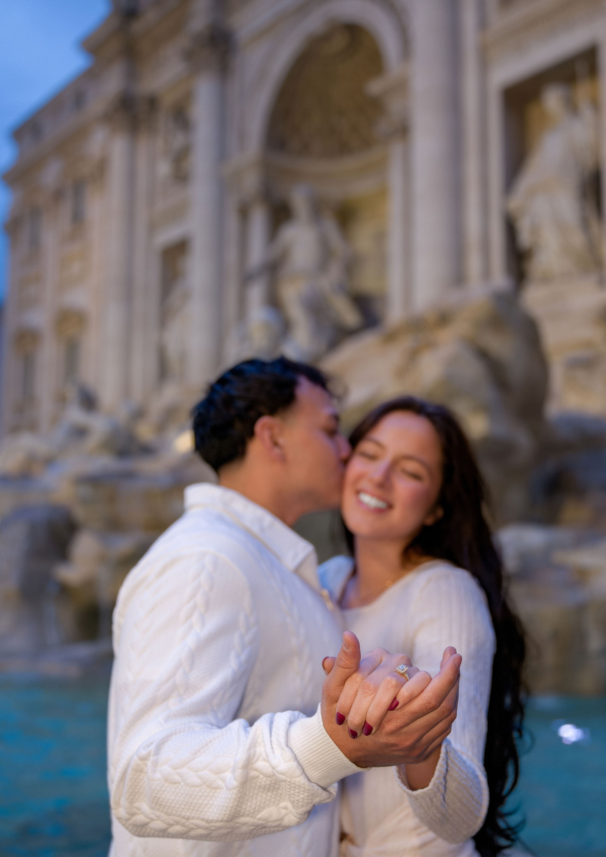 A tender moment at the Trevi Fountain, with the couple’s intertwined hands in the foreground.