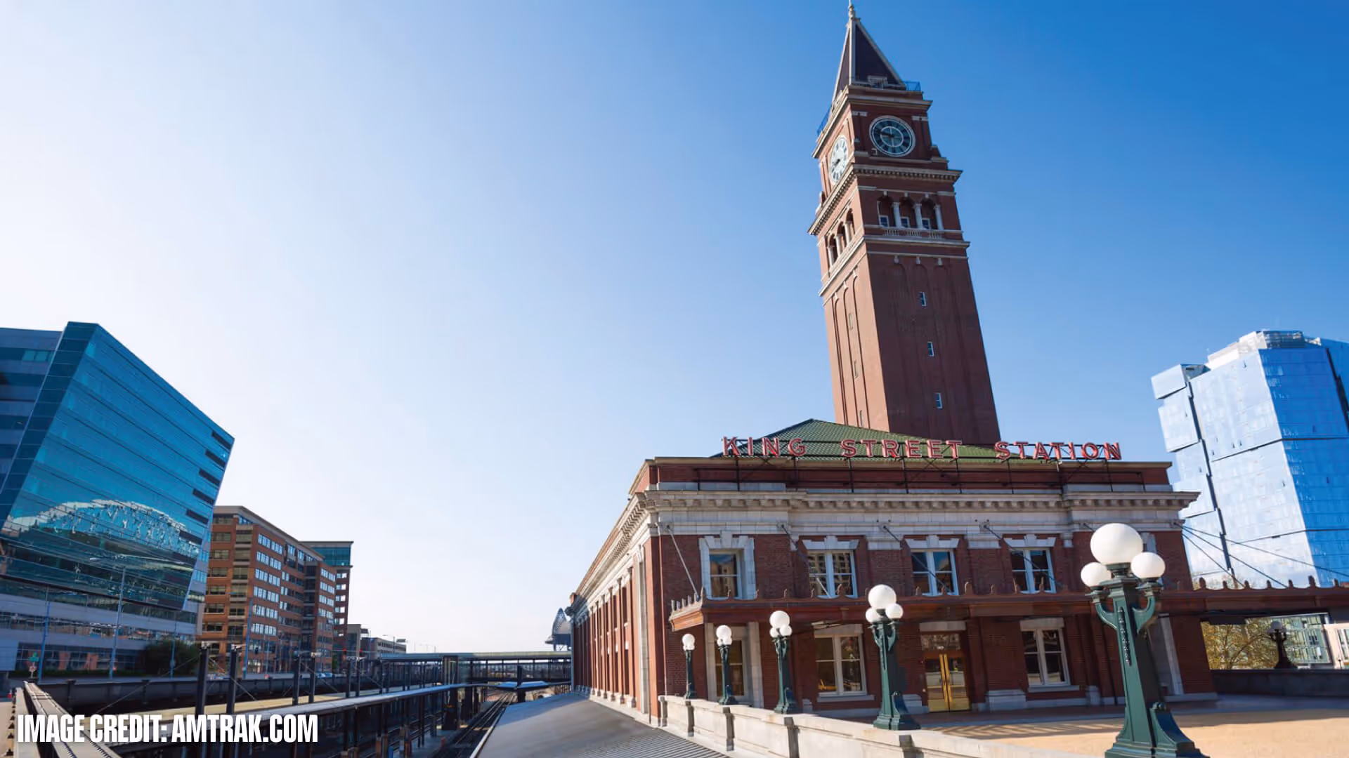 King Street Station with its tall clock tower under a clear blue sky, surrounded by modern buildings.