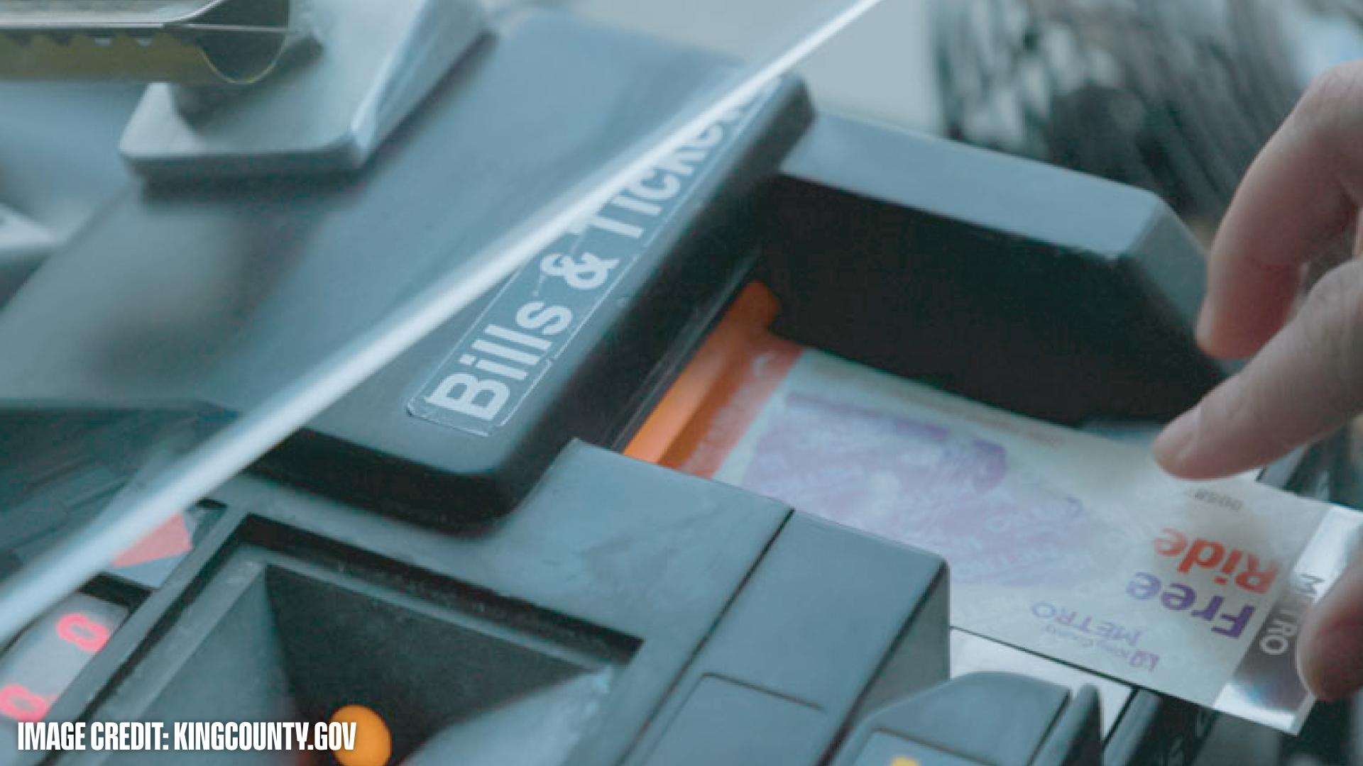 Hand inserting a Free Ride Metro ticket into a public transportation fare machine labeled 'Bills & Tickets'.