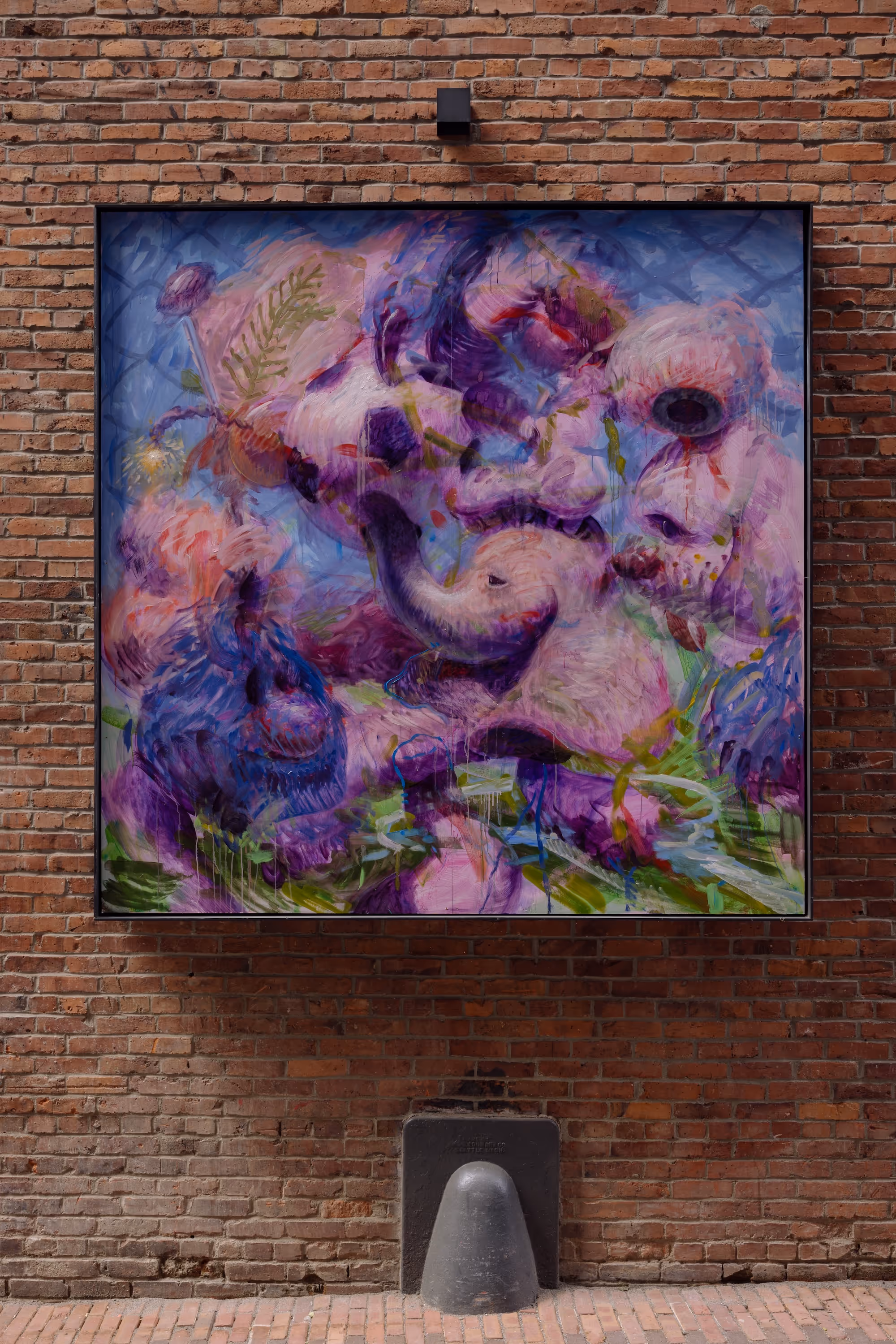 Abstract painting with purple, pink, and blue hues depicting animal and floral forms on a brick wall.