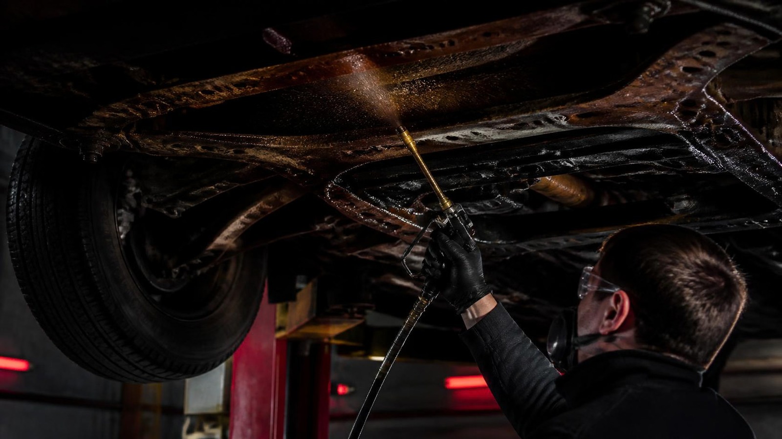 Mécanicien appliquant un traitement antirouille à l’huile et paraffine sous une auto, Garage Salvas à Sorel-Tracy