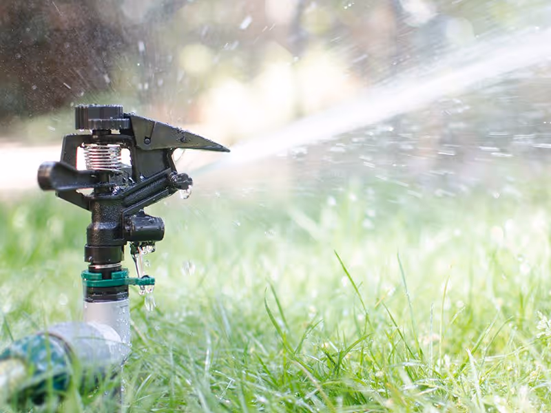 Sprinkler watering a bermuda grass lawn in Metro Atlanta during summer