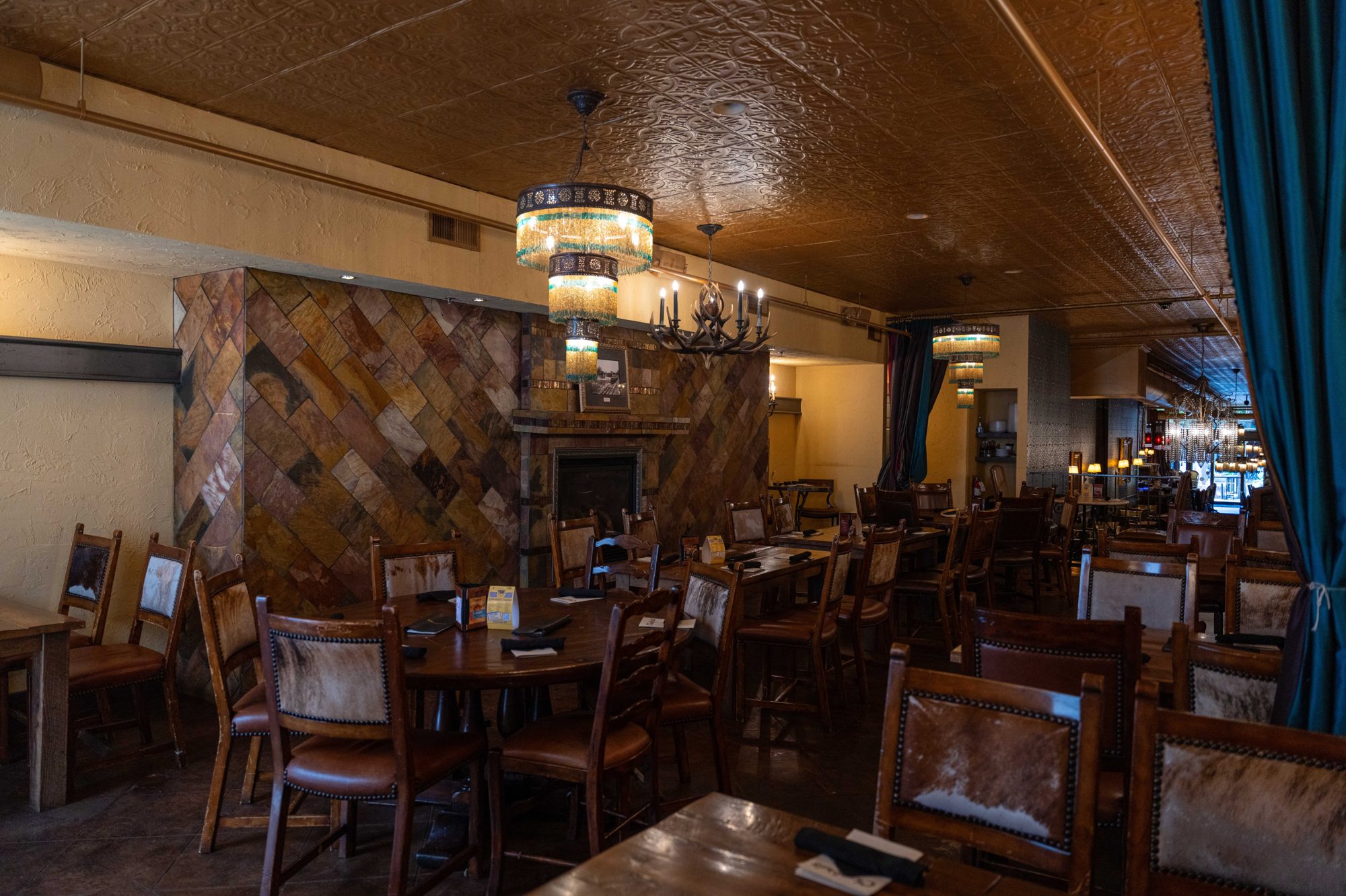 Crawford's upper level dining room with a slate fireplace, cowhide chairs and beaded chandeliers.