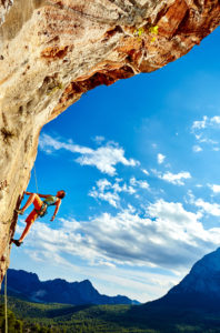 female rock climber climbs on a rocky wall