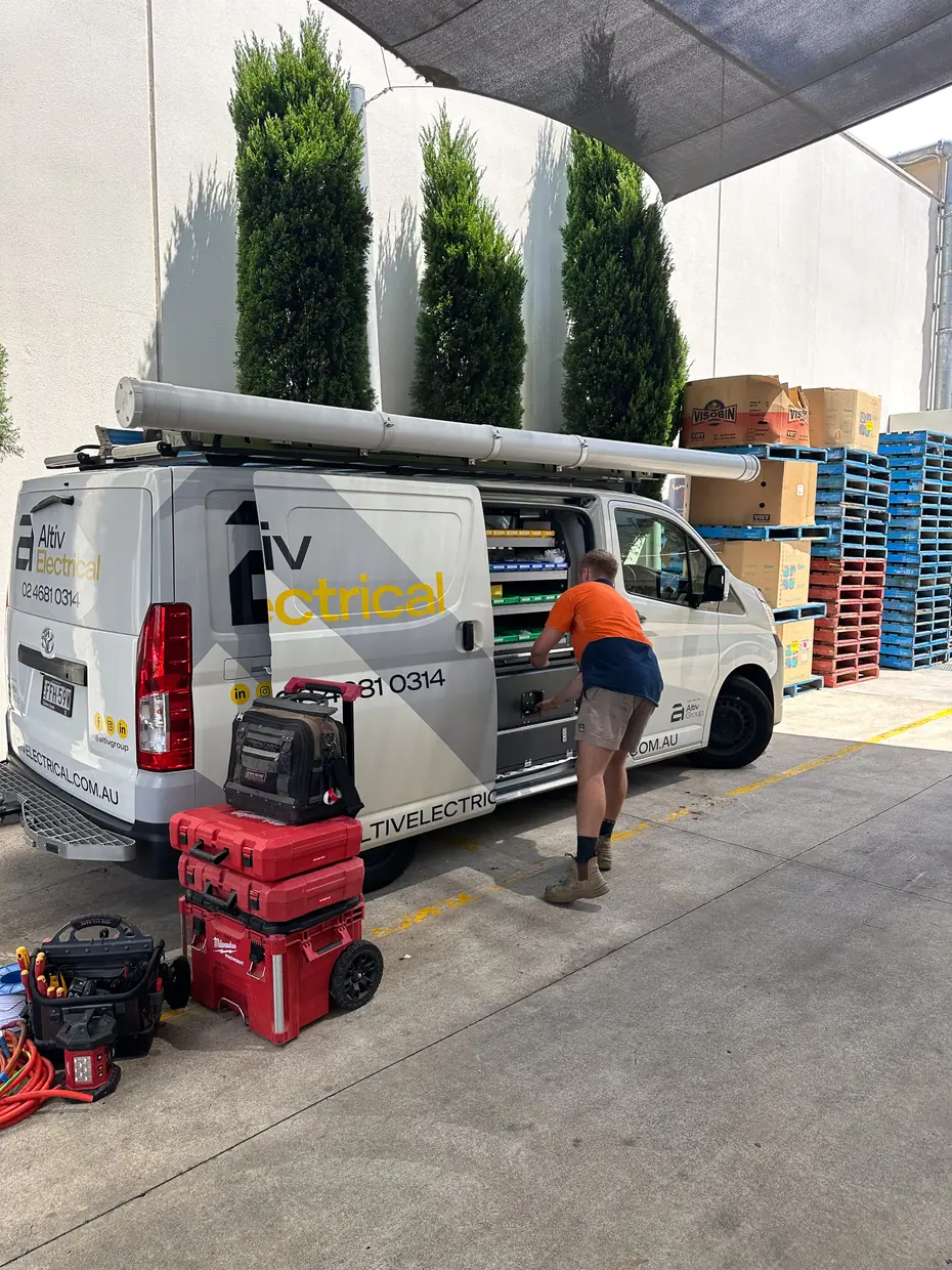 Altiv Electrical technician unloading tools from a branded service van
