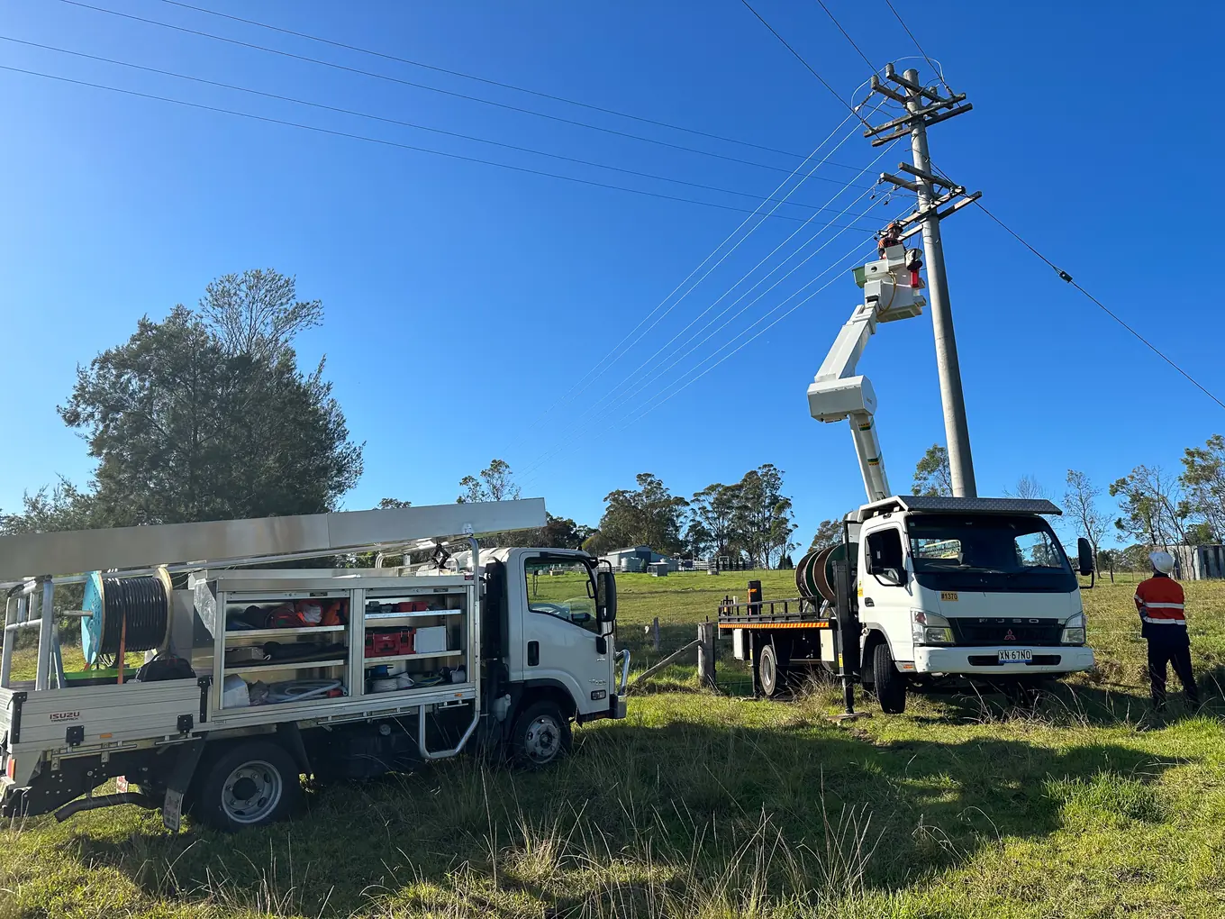 Elevated work platform raised to a power pole beside an Altiv Electrical truck