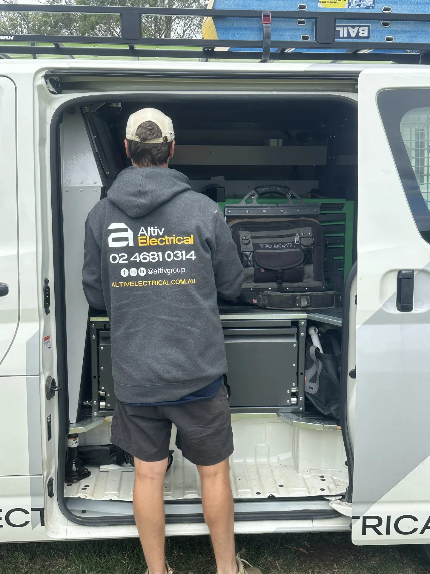 Altiv Electrical technician loading equipment into the back of a service van