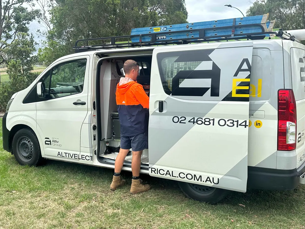 Altiv Electrical technician loading equipment through the van side door