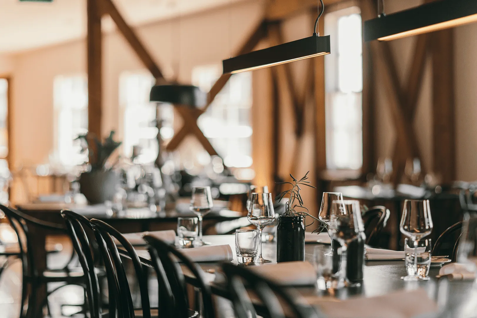 A hand holds a martini over a table full of food infront of a window.