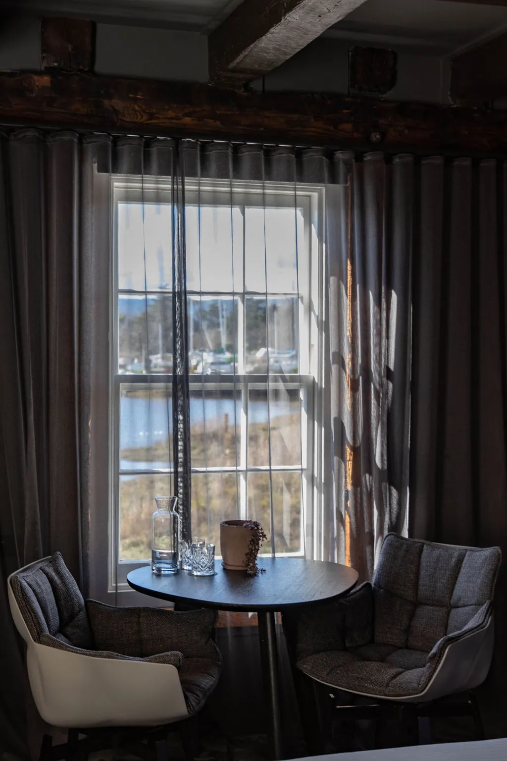 Room showing two comfortable chairs infront of a window overlooking the river. 