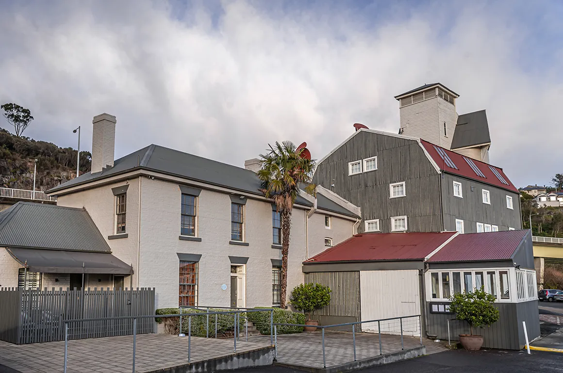 An old converted mill. With red and grey painted tin roof. It is a heritage property. 