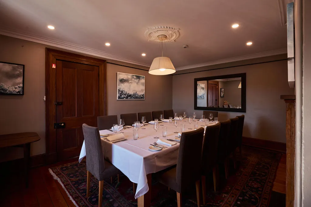 A beautifully set table inside a romantically lit room with art. 