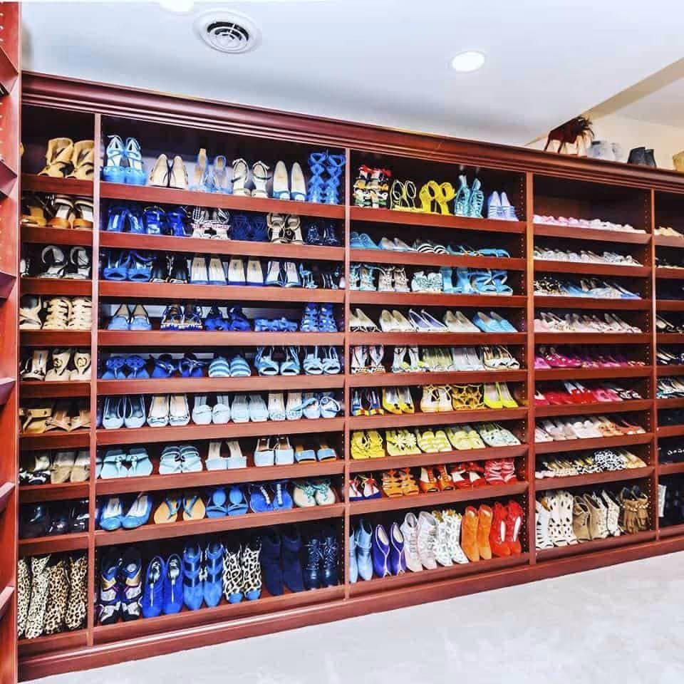 Shoes arranged by color in a walk-in closet.