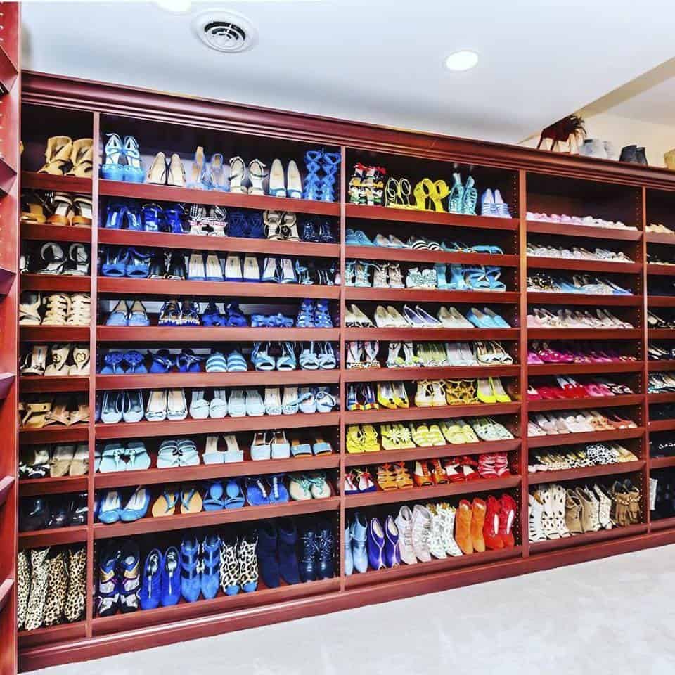 Shoes arranged by color in a walk-in closet.
