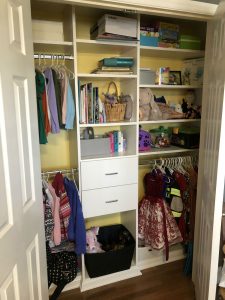 A child's closet organized with hanging rods.
