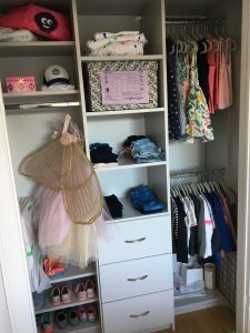 A children's shoes organized in a custom closet.
