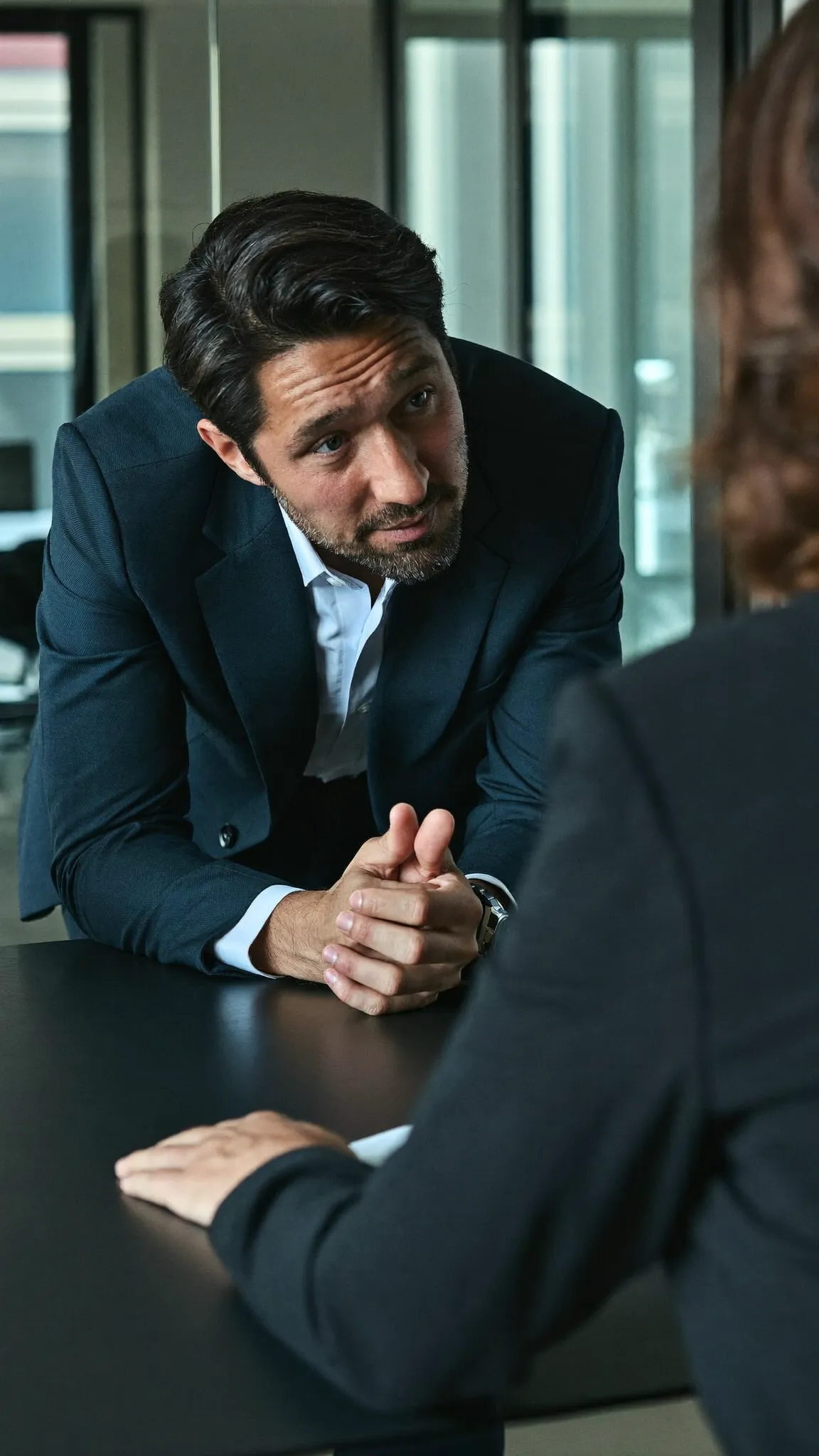 Salesperson leaning in to talk through a pitch with a client