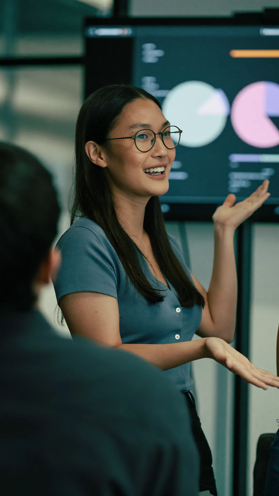 Data specialist explaining charts on a screen to colleagues