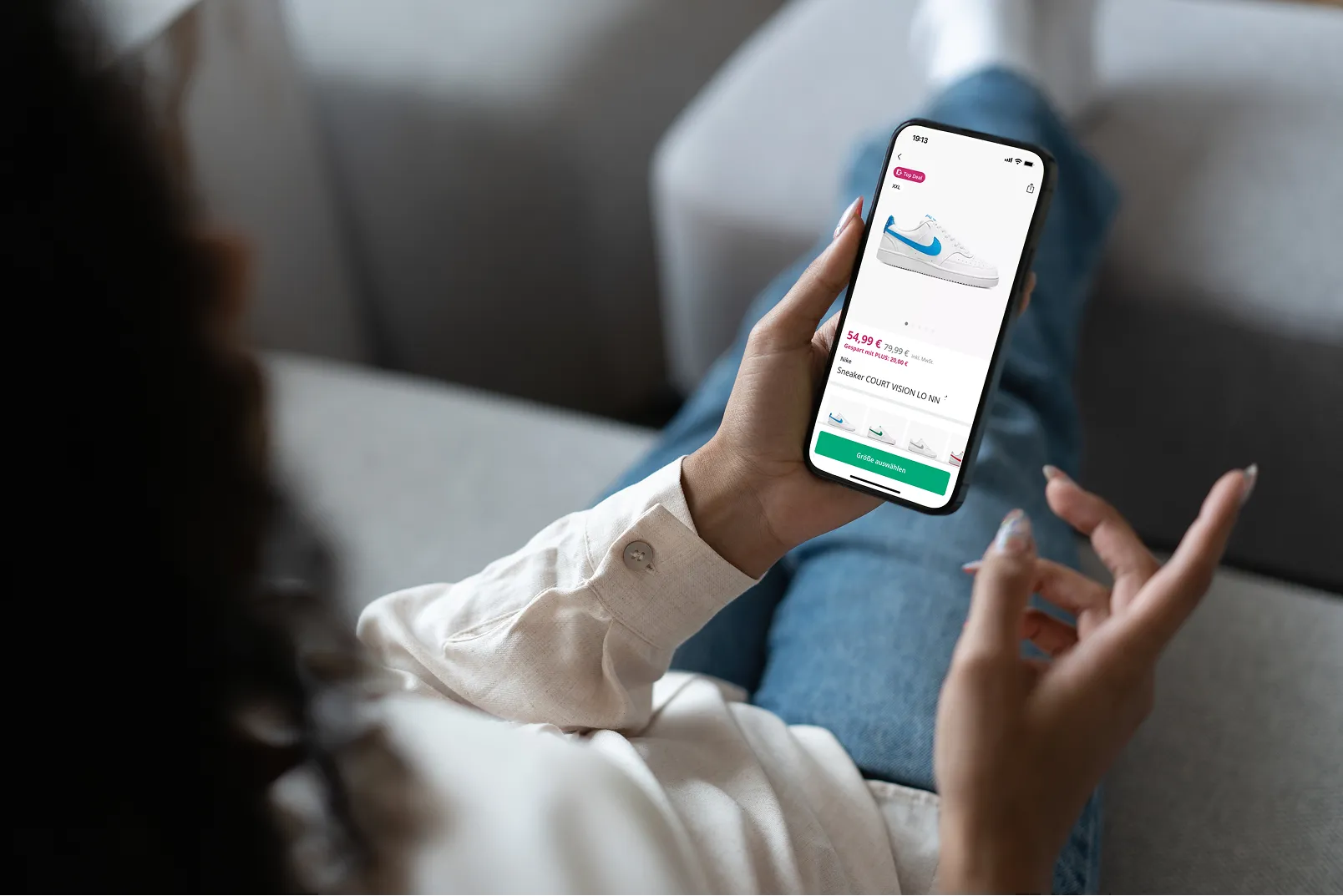 A woman using her smartphone to browse and purchase shoes from Deichmann.