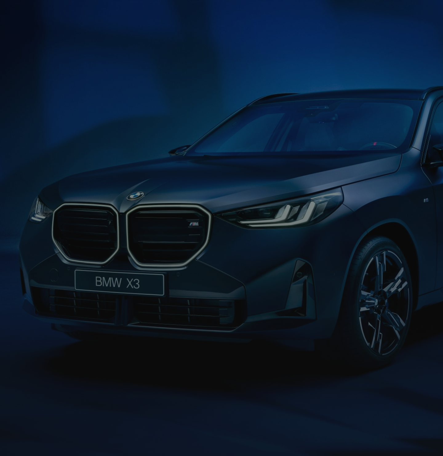 A car navigates a snowy road at night, illuminated by headlights against the dark, wintry landscape.