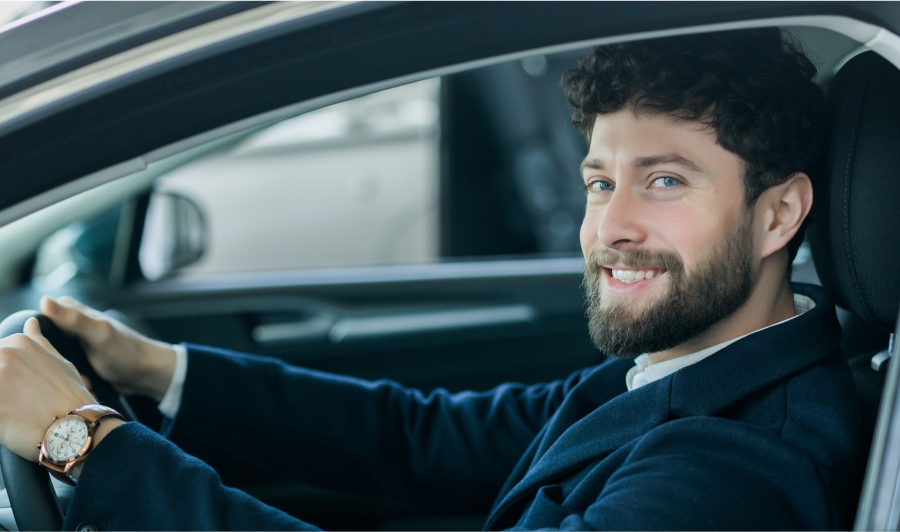 A man wearing glasses and a grey hoodie is focused on his work at a computer.