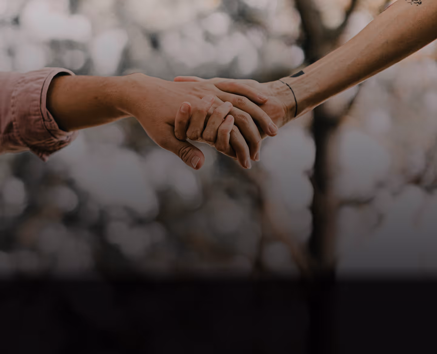 A man pushes a shopping cart with a woman sitting inside, both smiling and enjoying shopping trip.