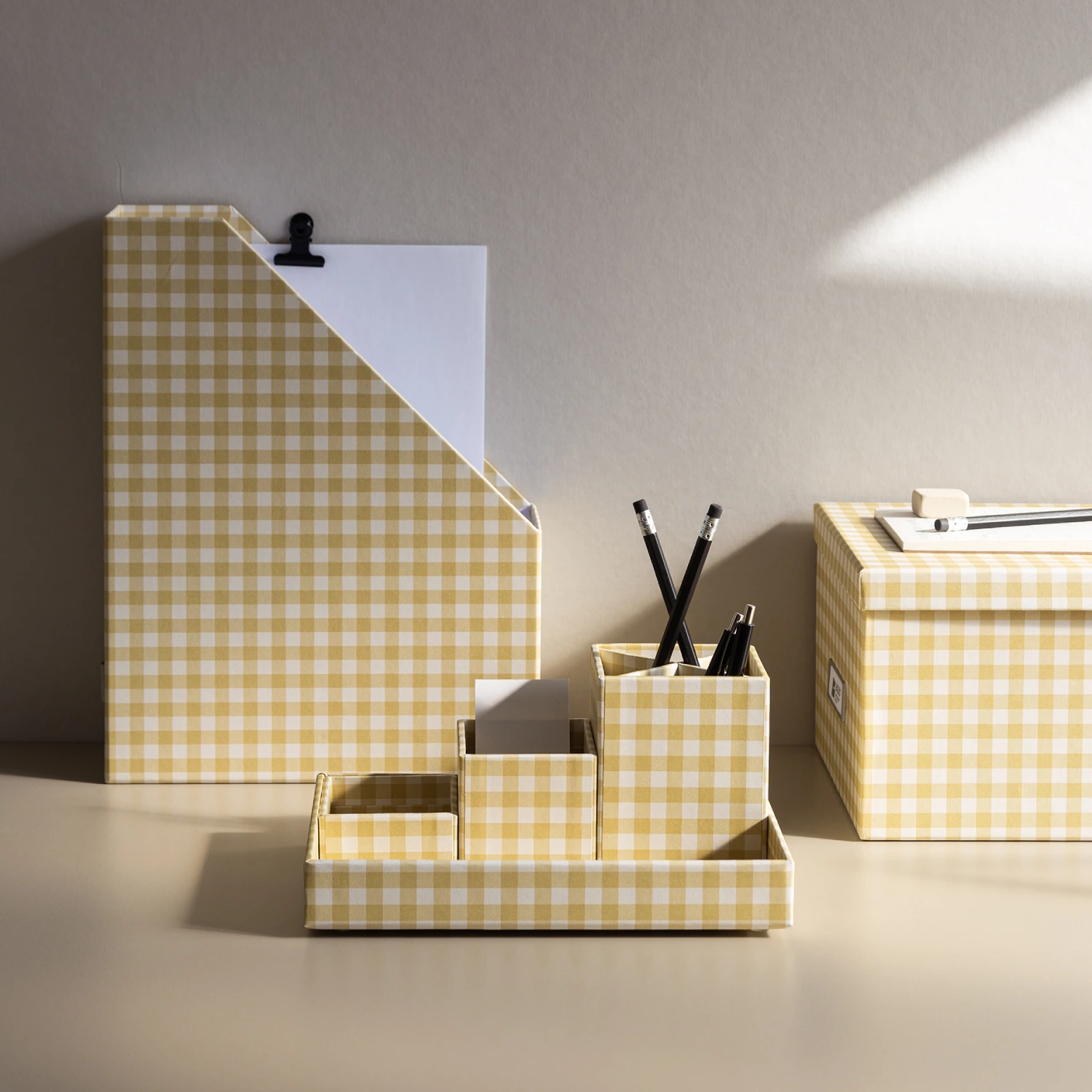 Bigso yellow checkered magazine holder, storage box, and desk organizer set for pencils, pens, and notes. Sustainable Scandinavian storage solution made from recycled fiberboard and paper, designed for stylish and eco-friendly office or home organization.