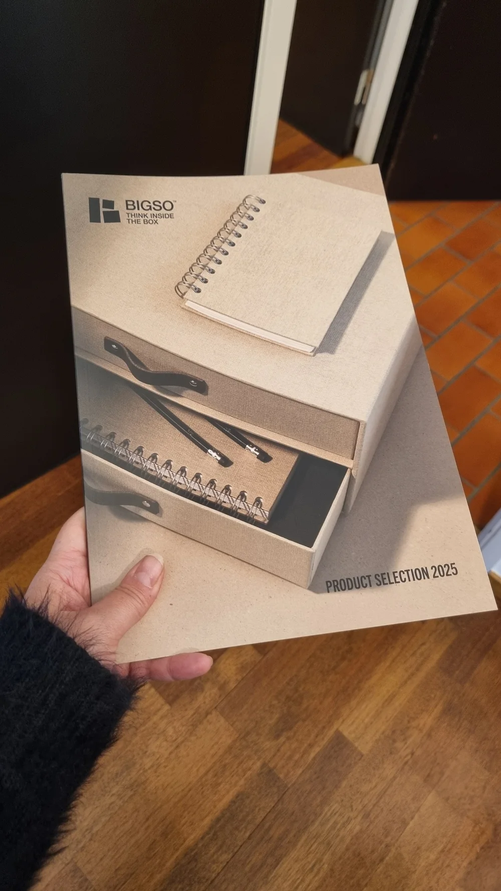Bigso Product Selection 2025 catalog cover featuring sustainable beige storage box with leather handles and notebooks, highlighting Scandinavian design and organization solutions.