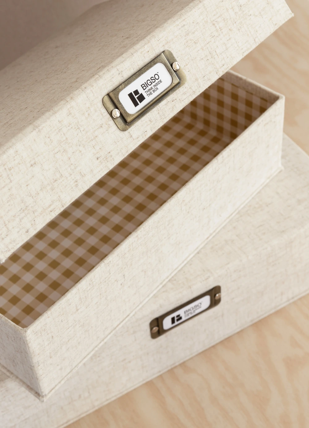 Bigso beige linen textile storage box with brass label holder, sustainable fabric design featuring a gingham check interior for elegant home organization.