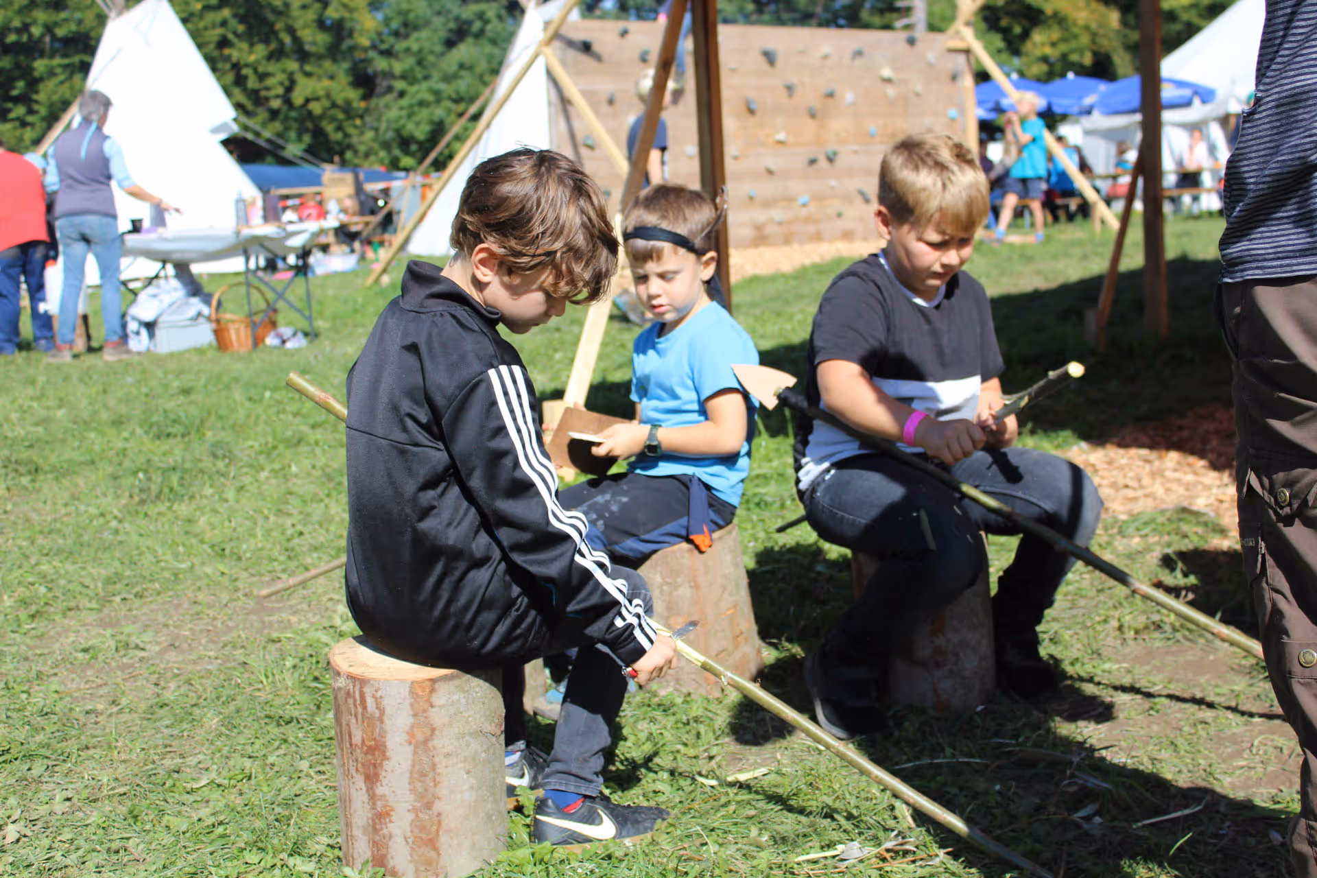 Kinder schnitzen Pfeil und Bogen Tipidorf