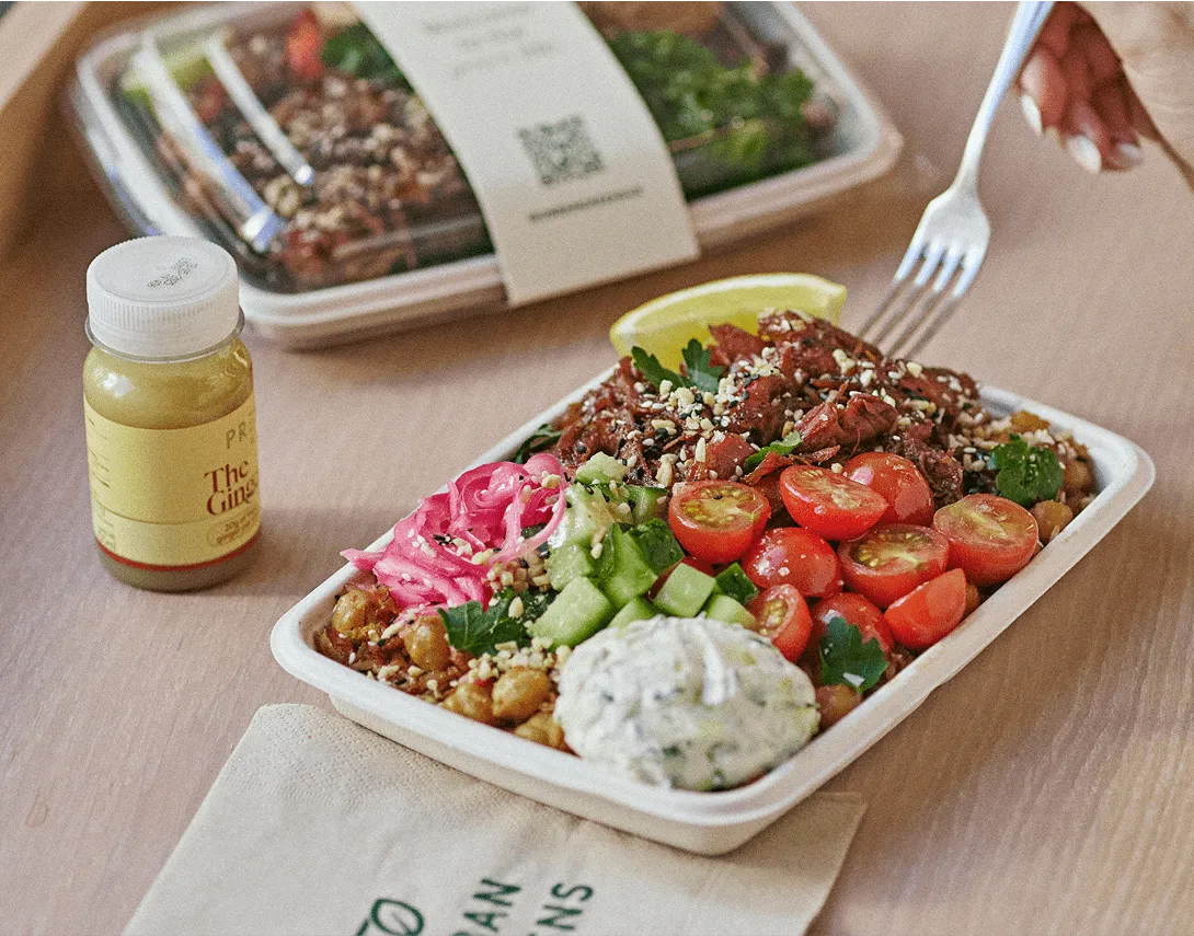 salad trays on table with a juice shot