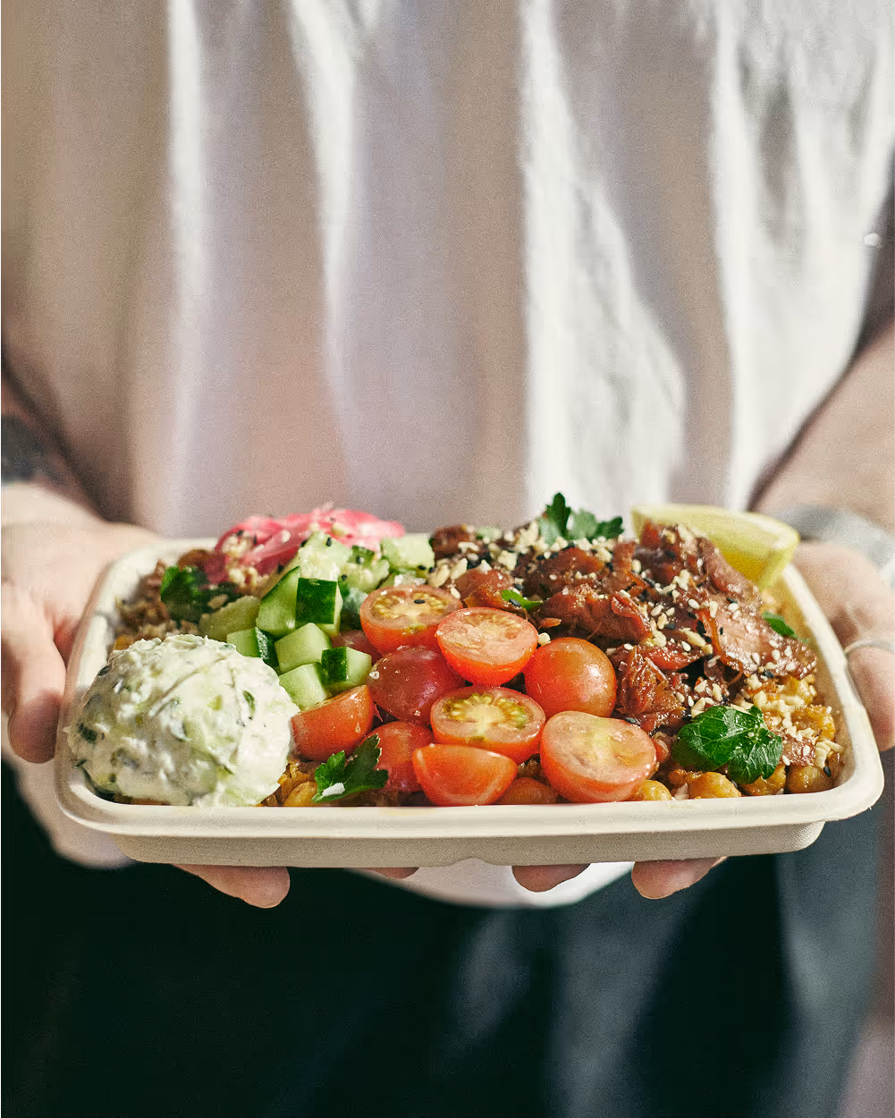 person holding urban greens salad tray
