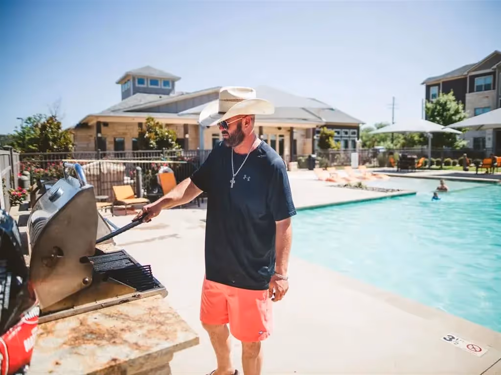 Guy grilling by pool