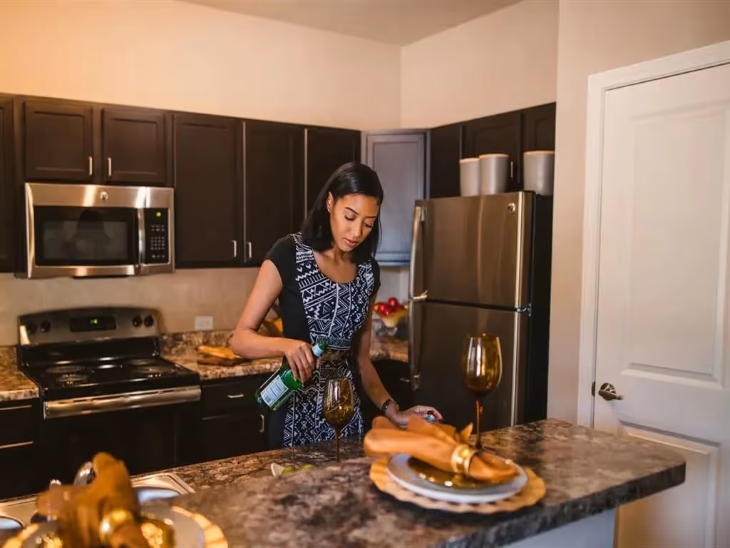 Woman pouring wine in kitchen