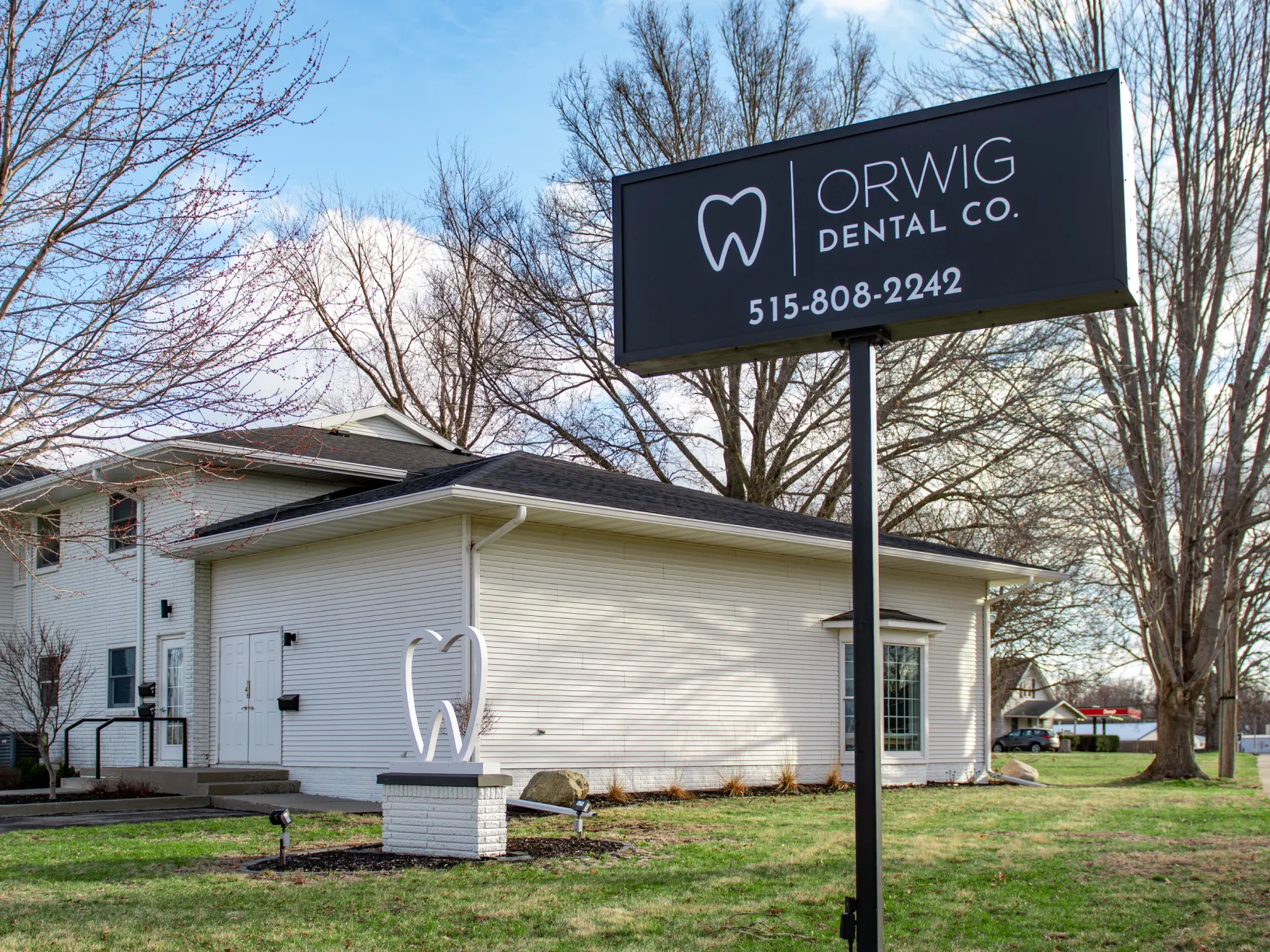 Exterior of Orwig Dental Co. building with a large sign displaying the logo, company name, and phone number 515-808-2242.