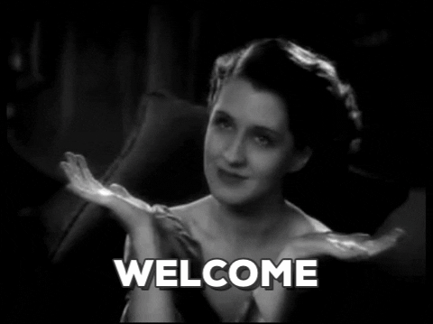 GIF of person opening their arms, smiling, and saying "Welcome"