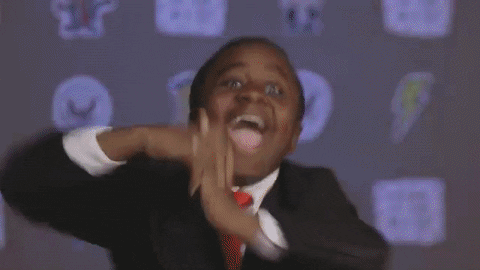 GIF of little kid with hands raised dancing for joy