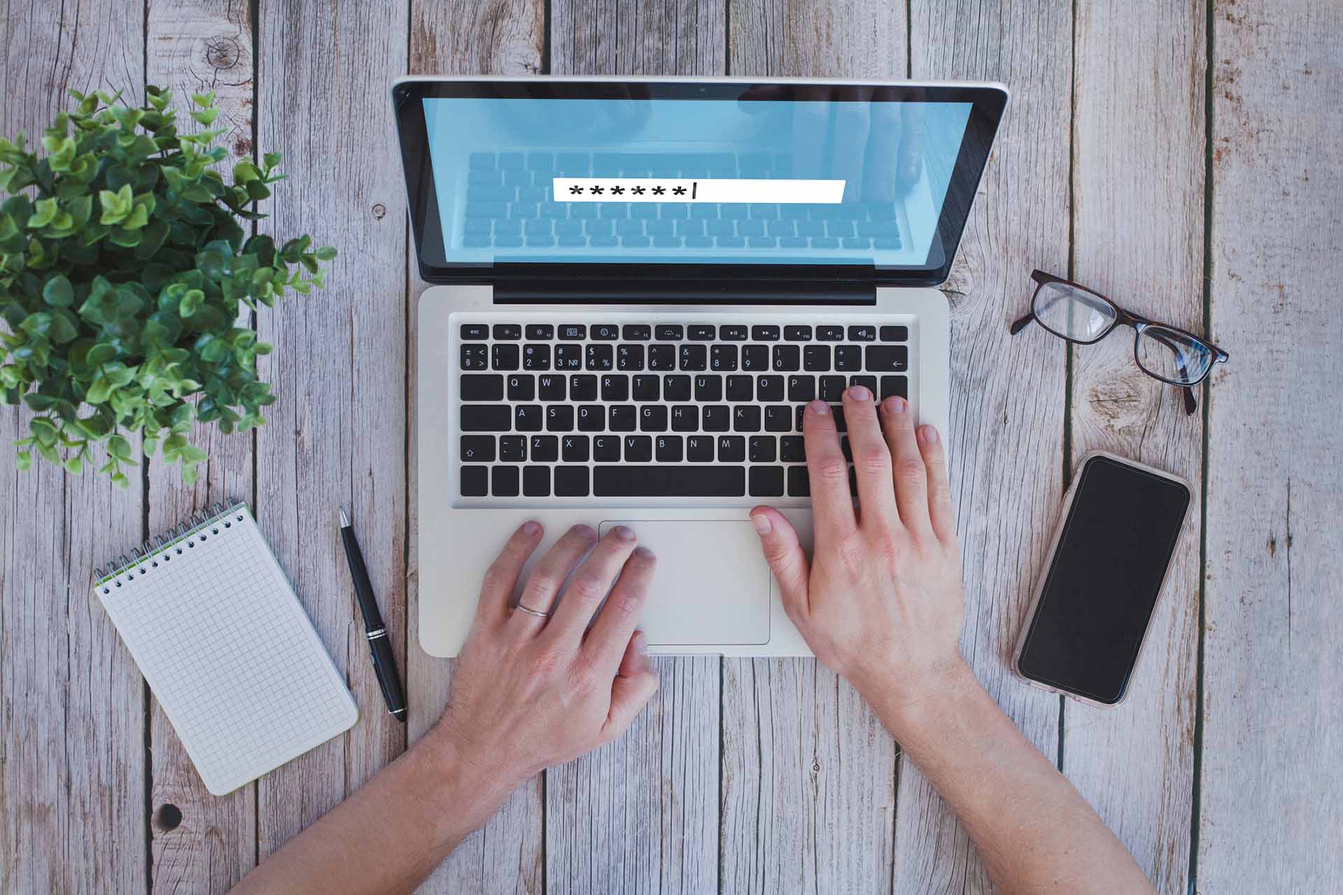 Person typing login password at a laptop computer