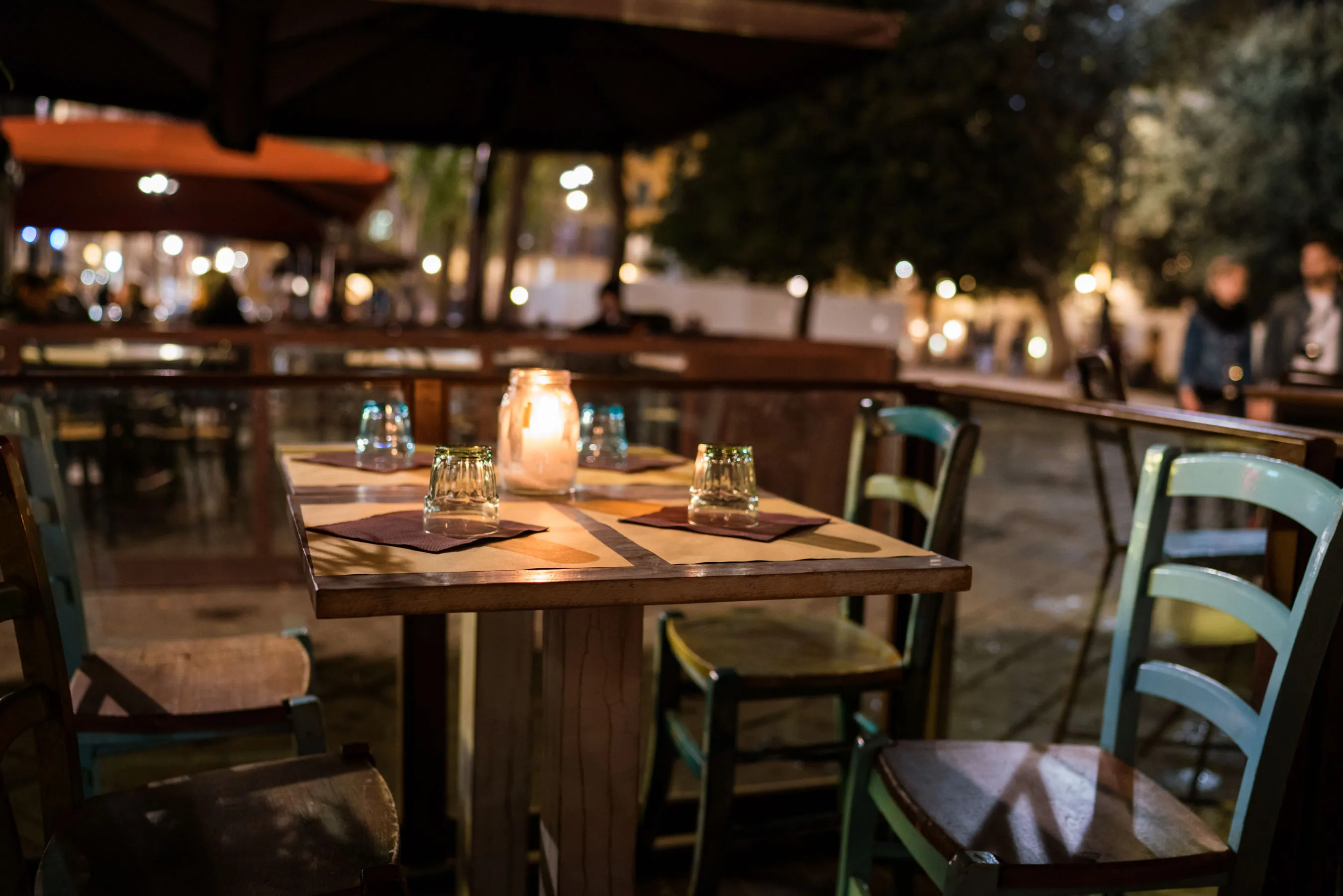 A candlelit table with chairs outside a restaurant