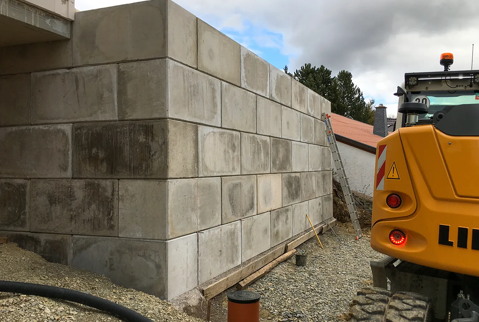 Baustelle mit Betonblöcken, die zu einer Wand gestapelt werden