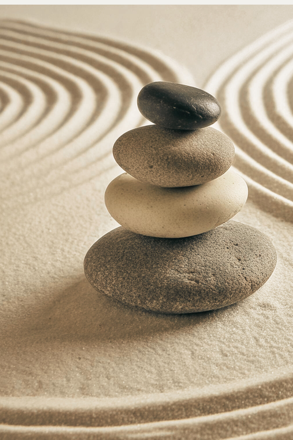 Gestapelde zenstenen in zand, symbool voor innerlijke balans en ontspanning zonder alcohol of middelen