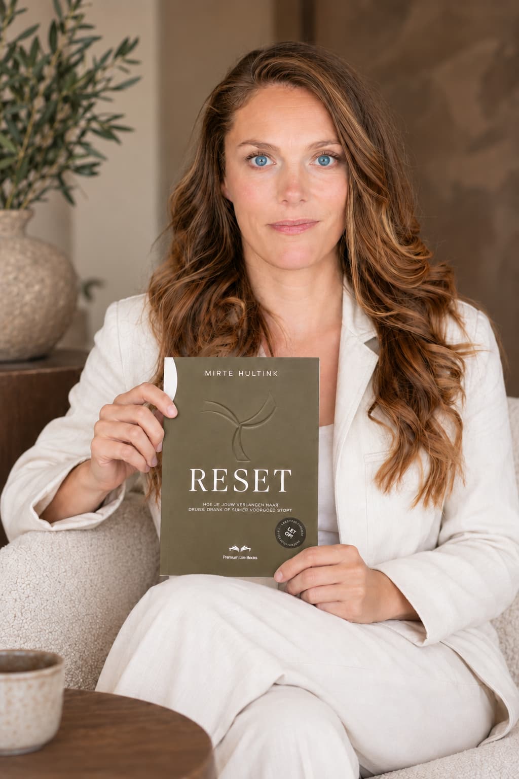 Mirte Hultink met het RESET-boek over het stoppen van verlangen naar drugs, drank of suiker.
